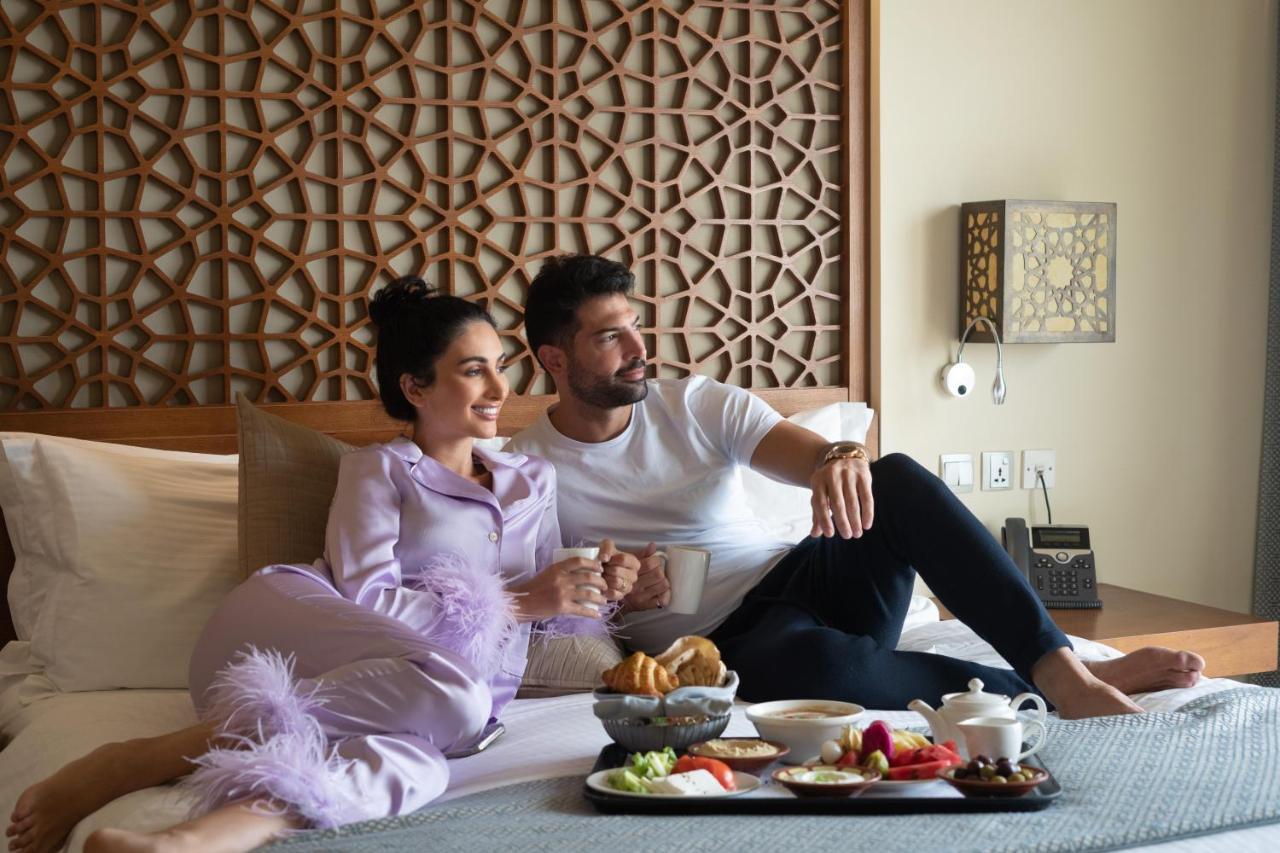 Fanar Hotel & Residences Salalah Exterior photo A couple having room service
